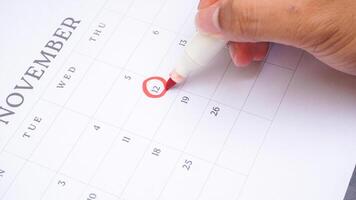 Red circle marked on a calendar at 12 of November isolated on black background for an important day photo