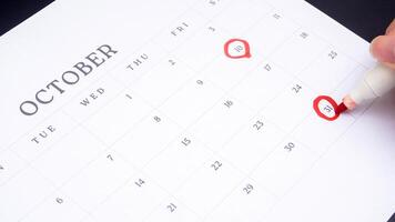 Red circle marked on a calendar at 10 and 31 of October as symbol of important day photo