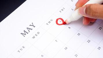Red circle marked on a calendar at 1 of May as symbol of important day photo