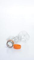 Empty crumpled plastic bottle waste with orange bottle cap isolated on white background photo