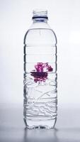 Water dripped with purple dye in plastic bottle isolated on white background photo