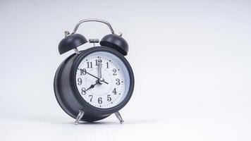 Black retro alarm clock shows 8 o'clock isolated on white background photo