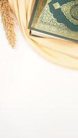Muslim decoration for Ramadan and Eid al-Fitr with holy Quran and beige fabric isolated on white background photo