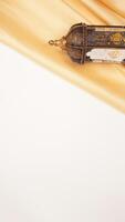 Muslim decoration for Ramadan and Eid al-Fitr with islamic lantern and beige fabric isolated on white background photo