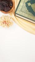 Muslim decoration for Eid al-Fitr and Ramadan with holy Quran, dates fruit, and beige fabric isolated on white background photo