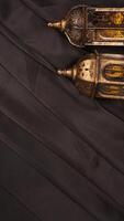 Muslim decoration with islamic lanterns for Ramadan and Eid al-Fitr on black fabric background photo