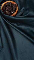 Muslim decoration with dates fruit for Eid al-Fitr and Ramadan isolated on dark green fabric background photo