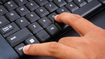 Close up on finger pressing ctrl or control and c shortcut keys on a computer keyboard for copy isolated on black background photo