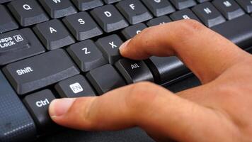 Close up on finger pressing ctrl or control and X shortcut keys on a computer keyboard for cut isolated on black background photo
