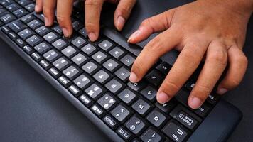 Finger texting on a computer keyboard isolated on black background photo