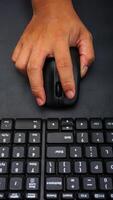 Computer keyboard with man hand holding computer mouse isolated on black background photo