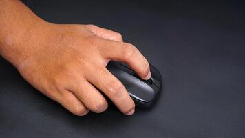 Man hand on computer mouse isolated on black background photo