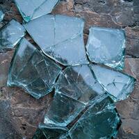Broken glass shards on a rough surface photo