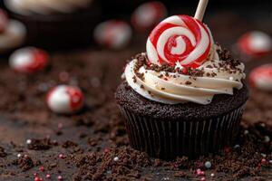 A delicious chocolate cupcake with white frosting and a lollipop photo