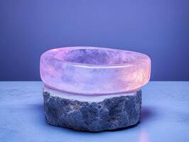 A pink crystal bracelet rests on a stone block photo