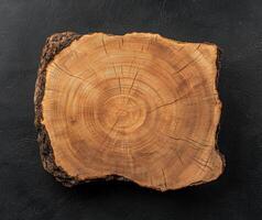 Cross section of a tree trunk showing growth rings on a dark background photo