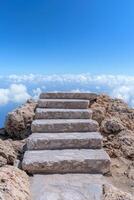 Stone steps leading up to a bright blue sky and clouds photo