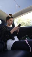 A Young Woman Actively Engaged in Various Smartphone Activities While Relaxing Inside Her Car video