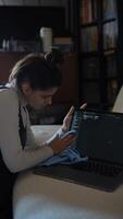 A person is thoroughly cleaning the screen of their laptop with a soft cloth while at home video