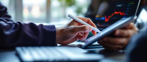 close-up of hands using stylus on tablet showing market graph photo
