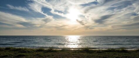 tranquil ocean sunset with golden sky and calm waves photo