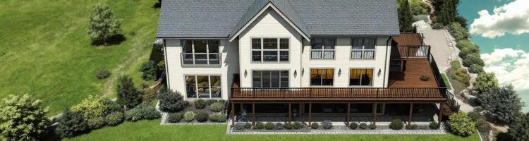 modern two-story house with a large deck and lush green surroundings photo