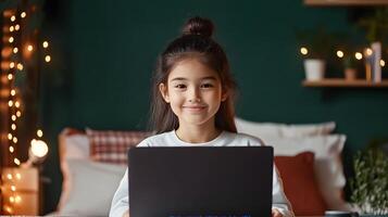 A young girl concentrates as she learns to code on a laptop surrounded by the cozy comforts of her bedroom and festive holiday photo