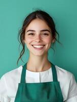 Cheerful and professional portrait of a young female housekeeper or service worker smiling against a vibrant green background photo
