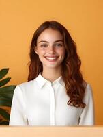 Friendly and approachable young woman with curly red hair and a warm smile dressed in a white shirt working as a front desk associate and providing customer service with enthusiasm and attention photo