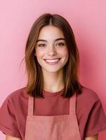 Closeup portrait of a cheerful friendly looking young woman with a warm smile wearing a red shirt and posing against a vibrant pink background photo