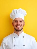 Portrait of a young cheerful chef in uniform standing against a vibrant yellow background showcasing his culinary expertise and passion for the industry photo