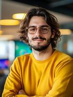 Portrait of a young enthusiastic game writer with curly hair and glasses smiling confidently in a creative studio setting photo