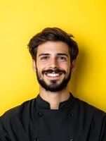Portrait of a confident youthful chef in a clean uniform smiling warmly against a vibrant yellow background photo