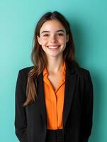 Portrait of a confident cheerful young woman dressed in a black jacket and an orange top smiling directly at the She appears to be a professional events manager based on her attire and demeanor photo
