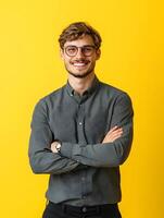 Portrait of a young smiling entertainment specialist posing confidently in a casual business attire against a vibrant yellow background photo