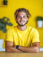 Smiling young man in a casual yellow shirt photo