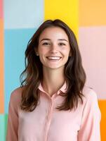 A young smiling interior designer poses in front of a colorful backdrop photo