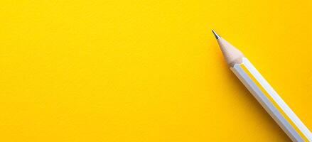 Yellow Pencil on Plain Yellow Background with Minimalist Workspace Concept photo