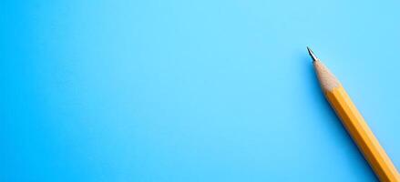 Sharpened Yellow Pencil on Vibrant Blue Background for Creative Office and School Supplies photo