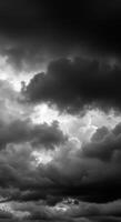 Dramatic dark clouds fill the sky, creating a moody monochrome cloudscape with soft light. photo