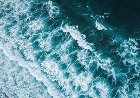 Ocean waves create foamy patterns in this overhead shot of the water's surface. photo
