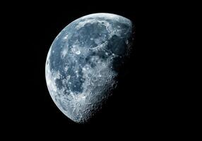 A detailed view of the moon's surface, revealing craters, and shadows in the vastness of space. photo