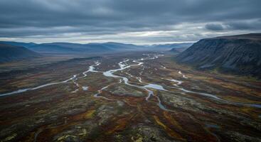 A captivating landscape view of a river weaving through a valley under a cloudy sky. photo