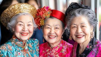 Three cheerful Asian senior women in traditional clothing and hats smiling for a portrait photo