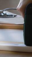 Vertical . Hands stretching canvas on stretcher bars with staple gun in workshop. Gallery wrap. Print on canvas. video