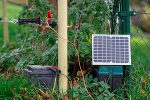 Small Solar farm, View of a small solar panel connected to a fence on a farm. photo