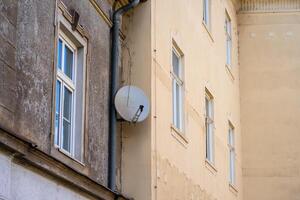 View of a satellite dish installed on the wall of a residential building photo