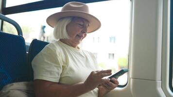 Senior woman using smartphone on a bus while traveling. video