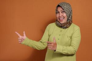 Friendly woman pointing with a cheerful expression, ideal for concepts like recommendations, direction, welcoming service, or product promotion visuals photo