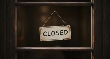 CLOSED sign hangs in the window of a wooden framed door. photo